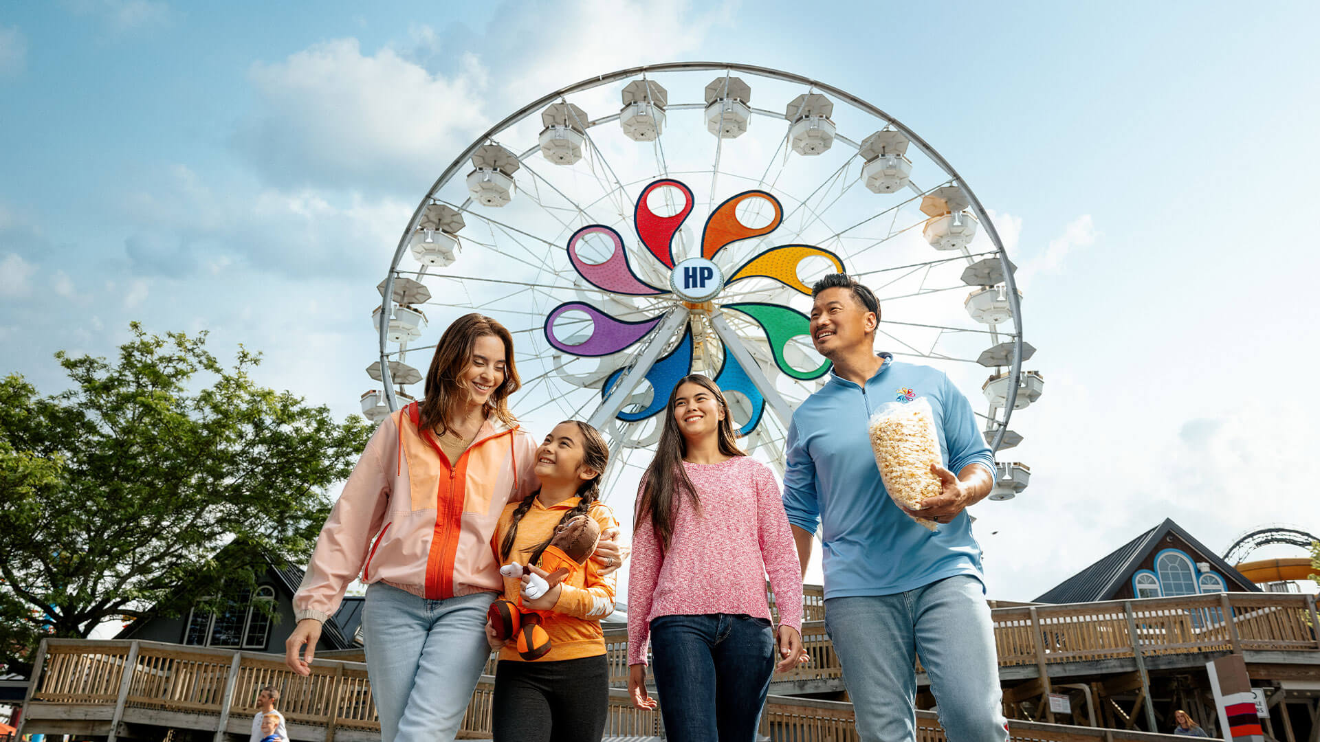 happy-family-holding-bag-of-popcorn-walking-under-ferris-wheel-at-hersheypark.jpg