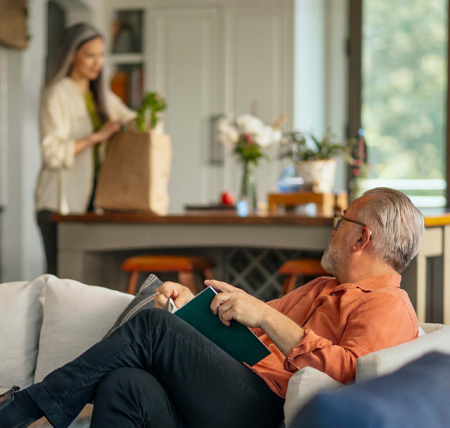 man reading on a couch, looking at a woman