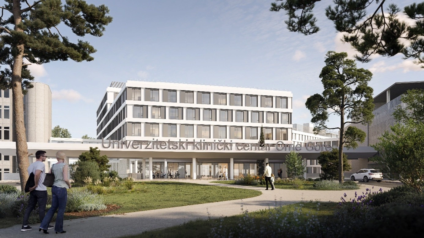 Bâtiment moderne d'un centre clinique universitaire au Monténégro avec pelouse et passants au premier plan sous un ciel dégagé.