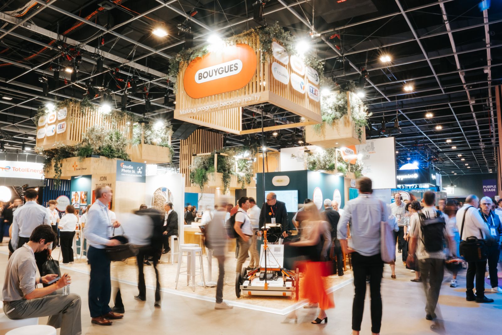 Stand du groupe Bouygues à Vivatech, de nombreuses personnes présentes, en mouvement et sur le stand.