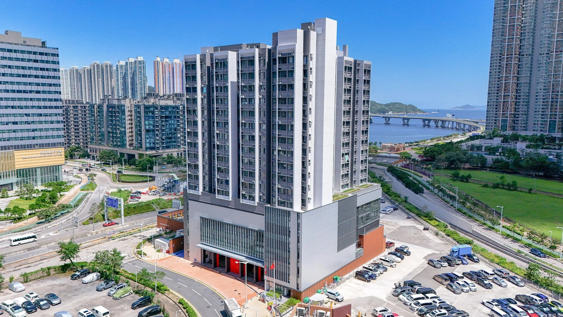 Caserne de pompiers et tour résidentielle à Tseung Kwan O, Hong Kong, surplombant la baie et le pont.
