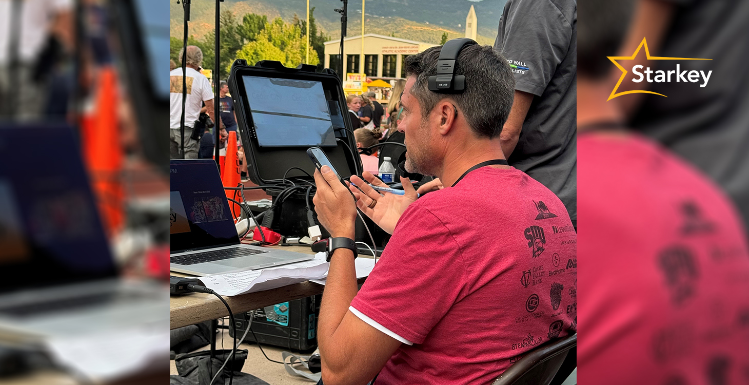 Image of Justin Osmond communicating from a producer's booth at an event