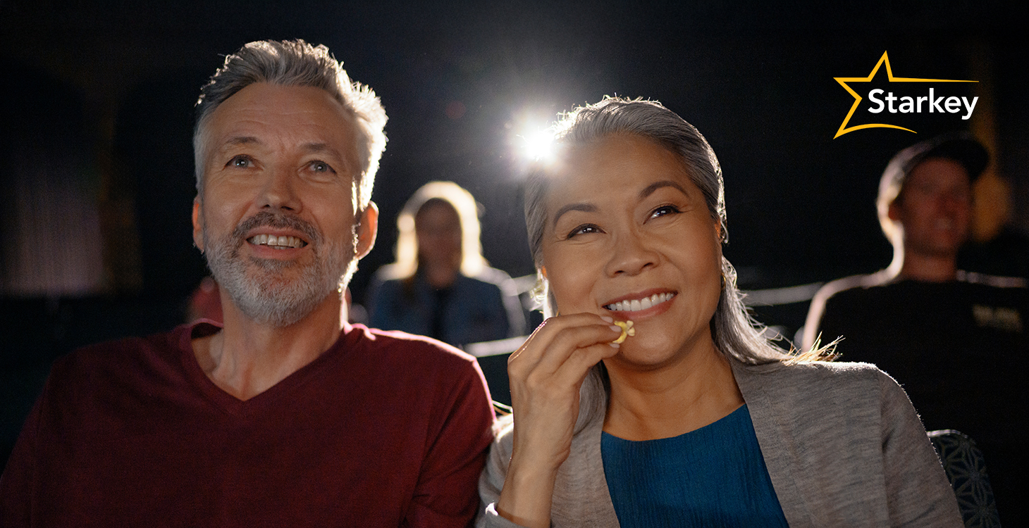 Image of middle-aged man and woman eating popcorn in a cinema