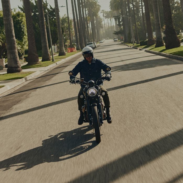 Man riding triumph motorcycle down the road whilst wearing the latest triumph motorcycle jacket the Jax