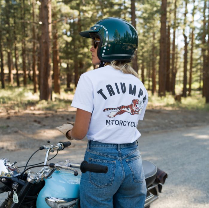 Man kneeling down wearing Triumph Heritage Team Coach Jacket