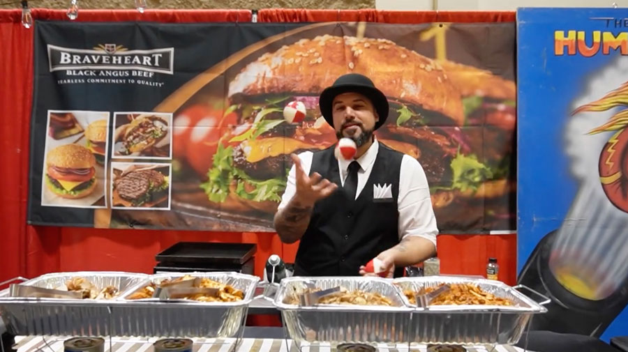 Man juggling at a food show themed The Greatest Show